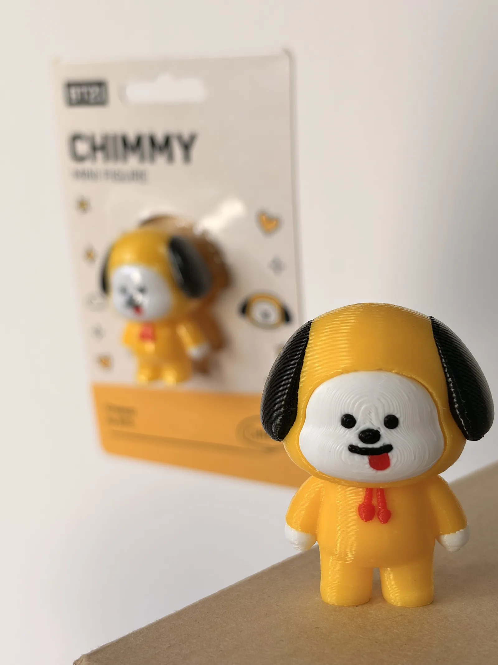 Mini figura de Chimmy impresa en 3D junto a su blíster